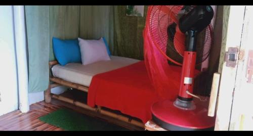 BacunganA&Z Nagtabon Lodge的小房间设有床铺和红色风扇