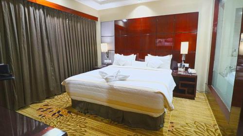 古尔冈SkyCity Hotel Gurgaon的一间卧室配有一张大床和大床头板