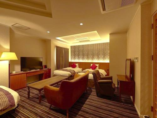 函馆La Jolie Motomachi的酒店客房设有一间带一张床和一张沙发的卧室