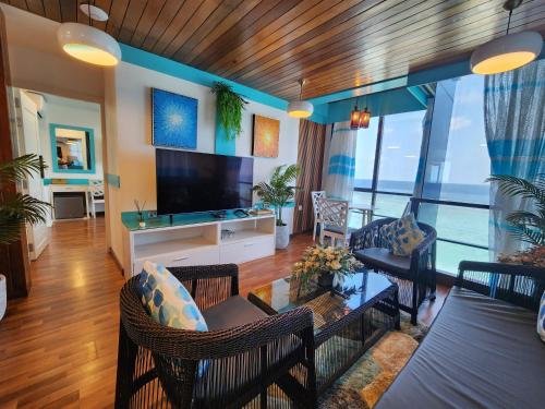 马累The Hive Beach的带电视的客厅和带沙发的客厅。