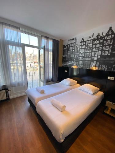 阿姆斯特丹老城区酒店的一间卧室设有两张床和大窗户