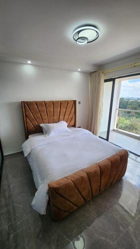 内罗毕Gatundu Heights的卧室设有一张大床,卧室设有大窗户