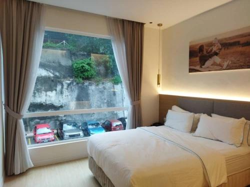 八打灵再也AP Concept Hotel的一间卧室设有一张床和一个汽车窗口