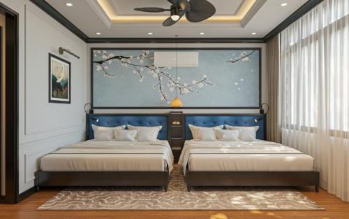 顺化Thuy Duong Boutique Hotel Hue的一间卧室设有两张床,墙上挂着一幅画