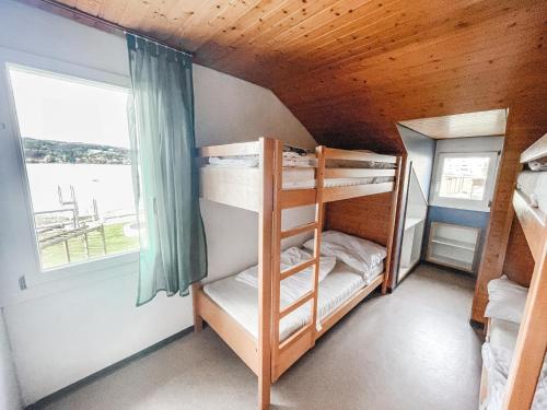 施泰克博恩Strandbad Steckborn mit Herberge, Camping & Glamping的小屋内的双层床间 - 带双层床