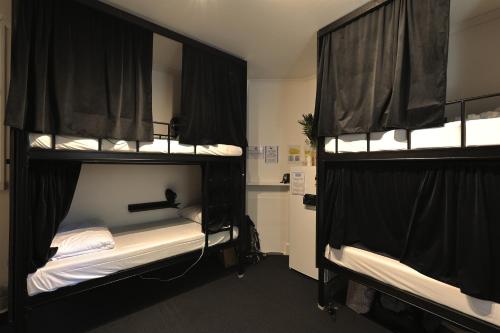 悉尼VENUS Potts Point - FEMALE ONLY HOSTEL - Long stay negotiable的客房内的2张双层床和黑色窗帘