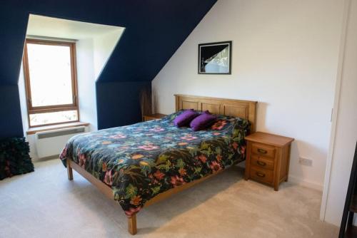 勒威克Stylish three-bedroom house in central Lerwick的一间卧室配有一张带紫色枕头的床
