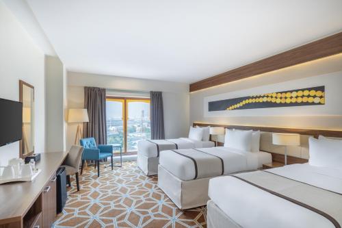 麦加Blue Coral Hotel的酒店客房设有两张床和电视。