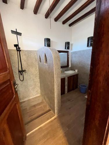 蓬圭Malcom Residence的浴室配有水槽和墙壁上的十字架