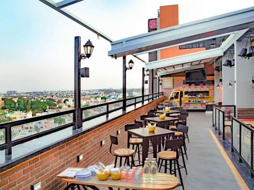 班加罗尔ibis Bengaluru City Centre - An Accor Brand的阳台餐厅,配有桌椅