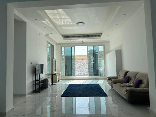 迪拜Centerpoint Duplex Villa的带沙发和大窗户的客厅