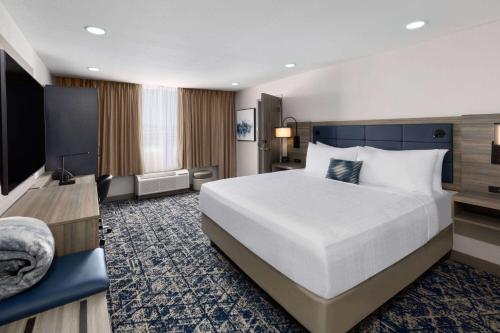 欧文Wyndham DFW Airport的酒店客房设有一张大床和一台电视。