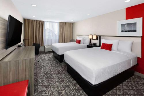 欧文Ramada by Wyndham DFW Airport的酒店客房设有两张床和一台平面电视。