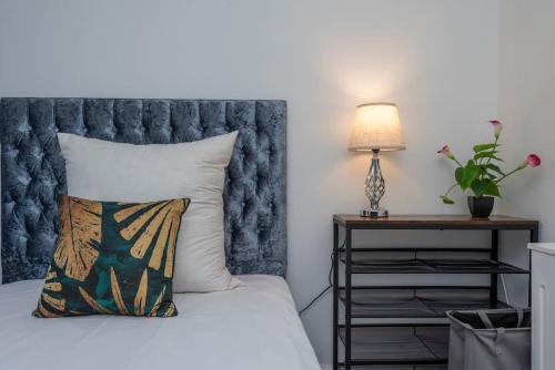 伦敦Stunning 3-Bed House的一间卧室配有一张带枕头和灯的床