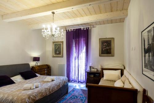 拉文纳Al Battistero Luxury Suite的一间卧室配有两张床、一张沙发和一个吊灯。