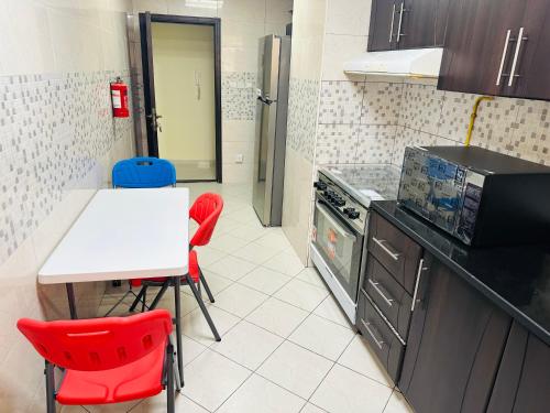 迪拜Private Room in beautiful Appartment的厨房配有桌子和红色椅子