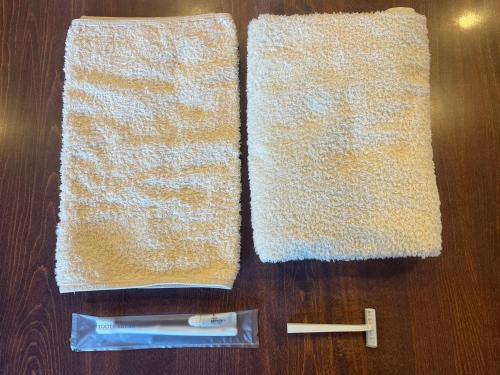 富士河口湖本栖湖畔 浩庵 Kouan at Lake Motosu的木桌上的两条毛巾,带牙刷和牙膏