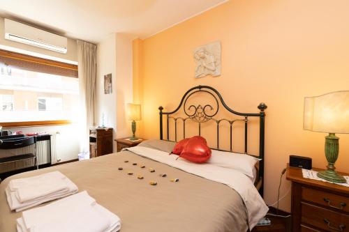 罗马Rachele’s charming house in the heart of Rome的一间卧室配有一张大床,上面有红色枕头