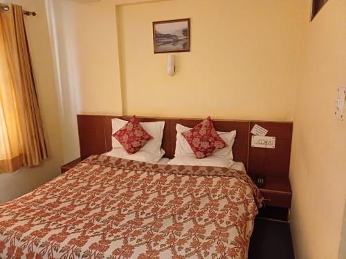 斯利那加Hotel Town Centre , Srinagar的配有枕头的床的酒店客房