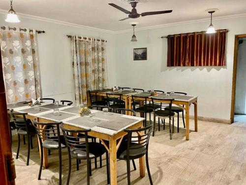 斯利那加Hotel Town Centre , Srinagar的用餐室配有木桌和椅子