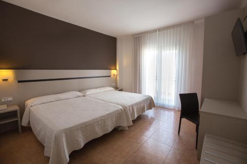 布拉内斯布拉瓦海岸酒店 的卧室配有白色的床和窗户。