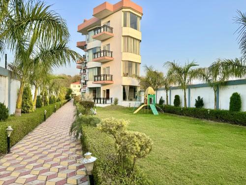 瑞诗凯诗Sumedha Resort & SPA Rishikesh的一座大建筑,在庭院前设有一个游乐场