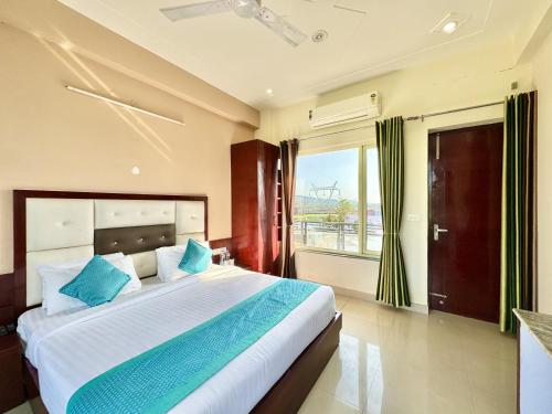 瑞诗凯诗Sumedha Resort & SPA Rishikesh的一间卧室配有一张带蓝色枕头的大床