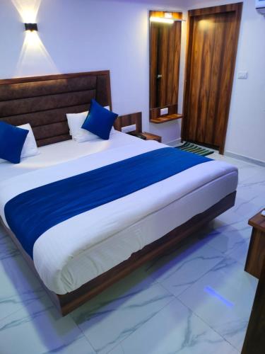 艾哈迈达巴德Hotel Angell Park的一间卧室配有一张带蓝色枕头的大床