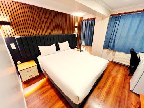 伊斯坦布尔奈拉酒店的卧室配有一张白色的大床,铺有木地板