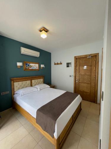 达特恰Veziroğlu Apart的一间卧室设有一张床和蓝色的墙壁