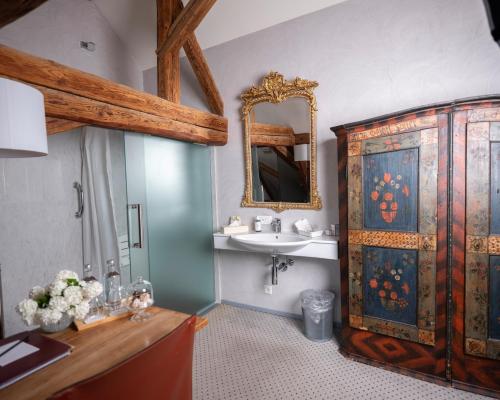 苏西Romantik Hotel de L'Ours的一间带水槽和木制橱柜的浴室