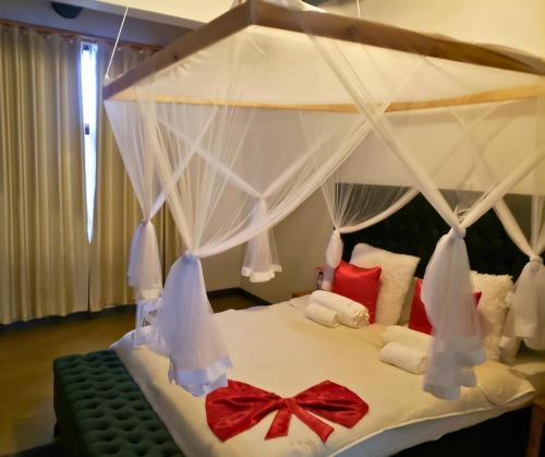 马普托Galo do Mar的一间卧室配有一张带天蓬的白色床