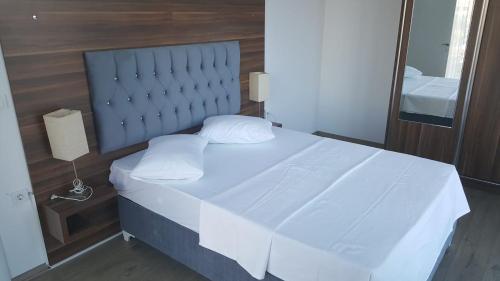 伊斯坦布尔伊斯坦布尔天空港酒店的白色的床,配有蓝色床头板和白色枕头