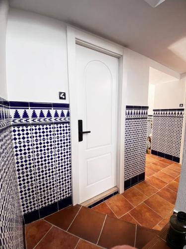 马拉加Shanti’s Andalusian Rooms的浴室设有白色门和瓷砖墙壁。