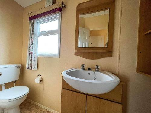 亨斯坦顿Superb Dog Friendly Caravan With Decking In Hunstanton In Norfolk Ref 13010l的一间带水槽、卫生间和镜子的浴室