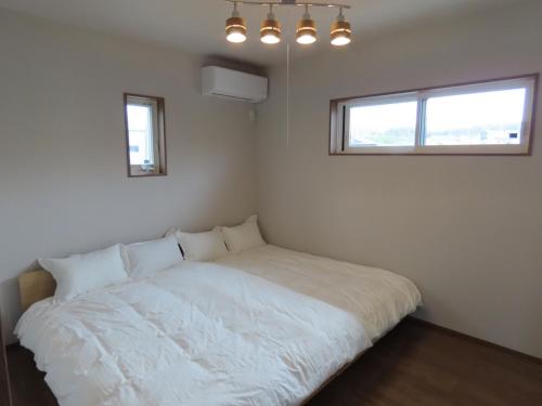 洲本市Awajishima Cottage Hitotoki - Vacation STAY 10755v的卧室配有白色床和2扇窗户