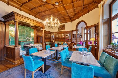 加尔米施-帕滕基兴艾森尼酒店的一间带桌椅和吊灯的餐厅