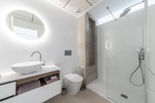罗哈莱斯Casa Marietha Apartment with swimming pool and roof terrace的白色的浴室设有水槽和淋浴。