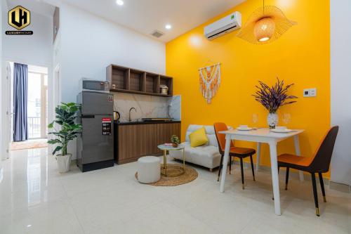 胡志明市Luxury Condotel Sai Gon 2的厨房以及带桌子和黄色墙壁的用餐室。
