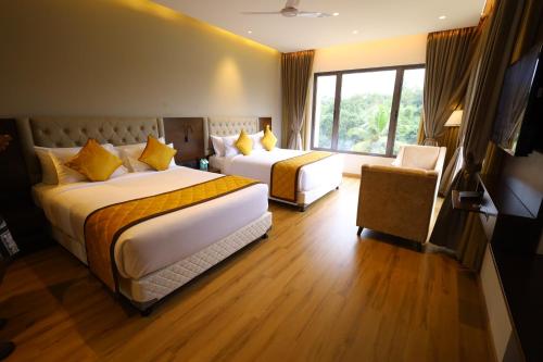 SubrahmanyaThe Aurum Subrahmanya的酒店客房设有两张床和窗户。