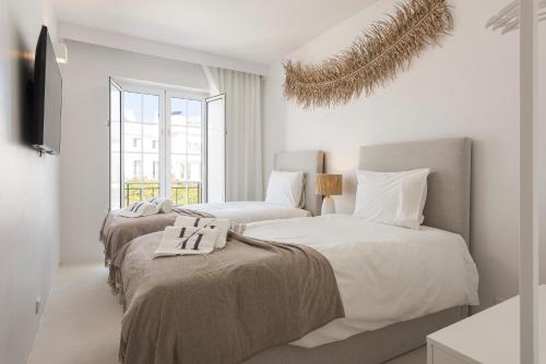 奎特里拉Modern Retreat: 3 Bedroom Villa in the Old Village的白色墙壁客房的两张床