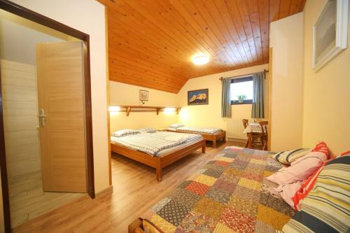克拉尼斯卡戈拉PLANINSKA KOČA NA GOZDU的一间卧室设有两张床和木制天花板