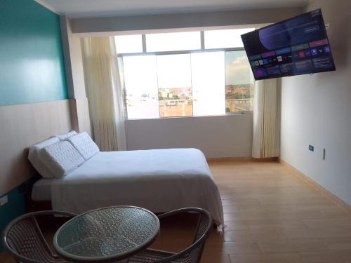 LambayequeHostal Tulipán Rojo的客房设有1张床、1张桌子和1台电视。