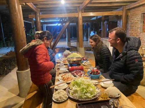 Hương Bá ThướcPuluong Aroma的一群人站在桌子旁吃着食物
