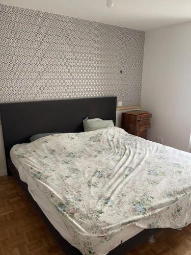 巴黎Pavillon sur cour .的一间卧室配有一张带花卉棉被的床
