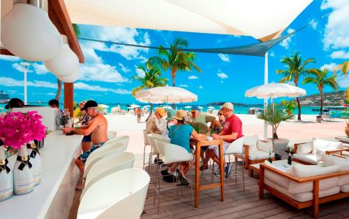 菲利普斯堡荷兰屋海滩酒店的一群人坐在海滩上的餐馆里