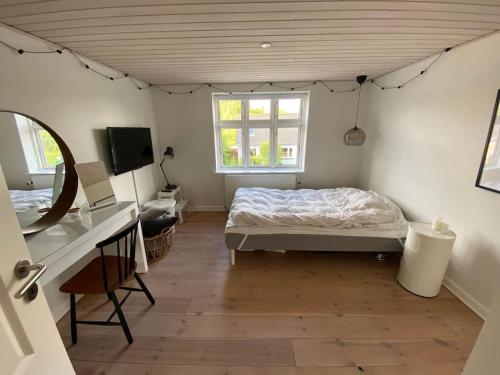 TommerupWonderful house & garden的一间卧室配有一张床、一张书桌和一个窗户。