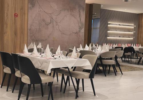萨拉热窝苏尔乔维奇酒店的用餐室配有桌椅和白色餐巾