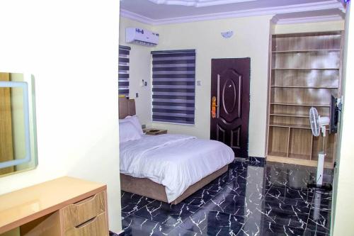 EgbaCozy Urban Oasis 3 Bedroom in Ogba, Ikeja, Lagos的一间卧室配有一张床,并在一间客房内配有电视。