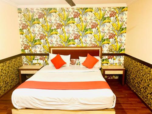 海得拉巴The City Park hotel的一间卧室配有一张带橙色枕头的大床